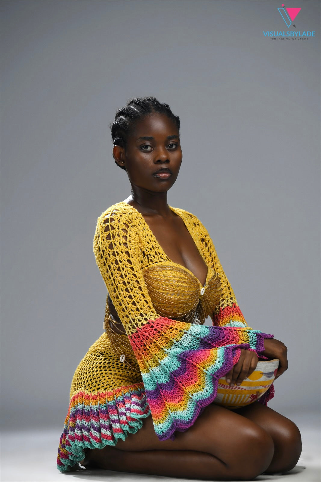 Woman wearing a colorful knitted garment on a gray background