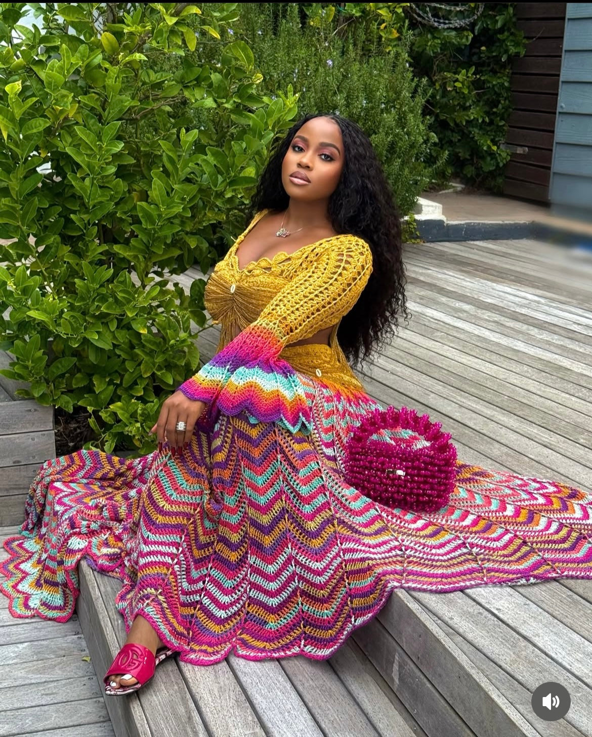 veekee james wearing hookedbylade crochet outfit in yellow and rainbow mix maxi sitting down