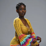 Woman wearing a colorful knitted garment on a gray background