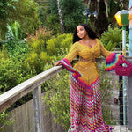 veekee james wearing hookedbylade crochet outfit in yellow and rainbow mix maxi standing